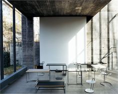 an empty room with several tables and chairs in it, all lined up against the wall