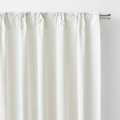 a white curtain hanging on the side of a window in front of a white wall