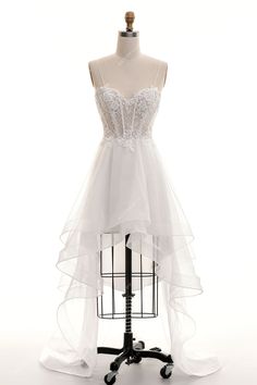 a white dress on a mannequin with sheer tulle and beadings