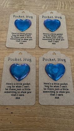 four blue heart shaped glass magnets sitting on top of a wooden table