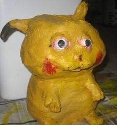 a close up of a statue of a yellow animal with red spots on it's face