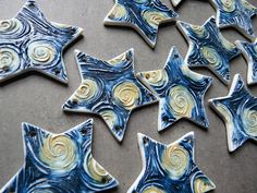 some blue and yellow stars are on a table with white swirly paper in the middle