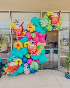 a large balloon decorated with cocktails and flowers in front of a storefront window