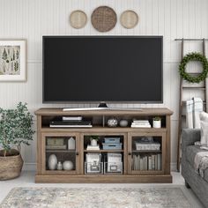 a flat screen tv sitting on top of a wooden entertainment center