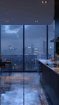 an empty kitchen with large windows overlooking the city lights at night in the rain storm