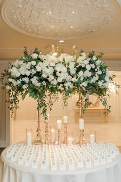 a table topped with lots of white flowers and candles