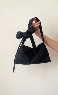 Black  Small  padded shoulder bag with tie up closure and bow on the shoulder. Made from organic vintage cotton. This bag is attributed to its timeless, versatile design. Would look cute with any outfit. It's sustainable and chic to retro aesthetics. We use our own patterns and designs. if you would like a different size please message us we can create a custom listing. Size Height 7 inches  width 10 inches  Debth 3 inches  WORLDWIDE SHIPPING  If you have an questions please reach out to us. we Black Shoulder Bag With Bow, Cute Bags Aesthetic, Vintage Bag Pattern, Fabric Bag Design, Bow Clothing, Mini Bag Pattern, Bag Customization, Shoulder Bag Pattern, Aesthetic Bag