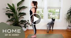 a woman standing on a yoga mat in front of a dog