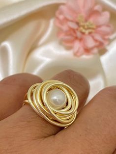 "Beautiful and Unique Gold Wire Wrapped Ring, ideal for an special gift for her, perfect to give any outfit a classic, feminine look. This modern pearl ring makes a great gift for bridesmaids and women of any age. This ring is made with a 3mm round pearl and wrapped in non tarnish gold wire, it is made to order on the size of your choice (see variations). Available in tree different wire tones Gold, rose gold and silver. I T E M ~D E T A I L S Materials: Gold Plated Wire, Pearl. Size: See Variat Gold Pearl Rings As A Gift, Round Metal Pearl Ring As Gift, Pearl Ring For Anniversary, Round Metal Pearl Ring For Anniversary, Anniversary Pearl Ring With Round Metal Setting, Elegant Wire Wrapped Ring As Gift, Gold Wire Wrapped Pearl Ring Gift, Elegant Wire Wrapped Round Rings, Elegant Wire Wrapped Ring For Gift