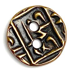 a metal button with two holes in the middle and an arabic letter on one side