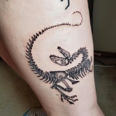 a tattoo on the leg of a person with a lizard in it's body