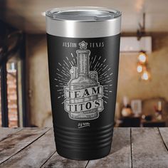 a black and silver tumbler sitting on top of a wooden table