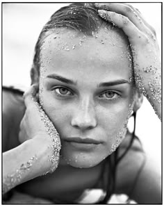 a black and white photo of a woman covered in soapy water with her hands on her head