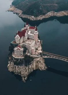 an aerial view of a castle on top of a small island in the middle of water