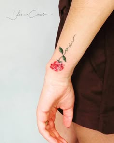 a woman's hand with a rose tattoo on her left wrist and the words i love you written in cursive writing