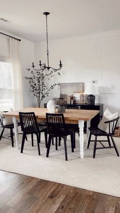 a dining room table with black chairs and a chandelier