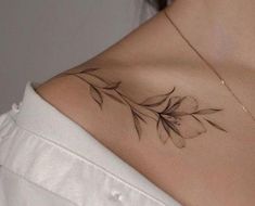 a woman's shoulder with a leaf tattoo on her left shoulder and the back of her neck