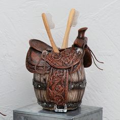 two toothbrushes in a brown leather purse on top of a metal table next to a white wall