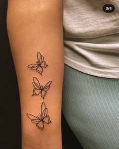 a woman's arm with three butterflies tattoo on the left side of her arm