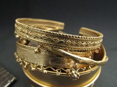 a stack of gold bracelets sitting on top of a table