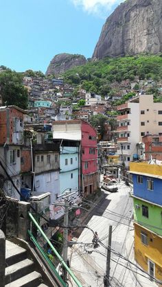 a city with lots of buildings and mountains in the backgrouds, as well as stairs leading up to them