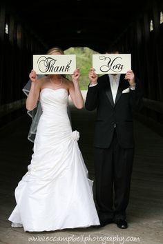 the bride and groom are holding up signs that say thank you on their wedding day