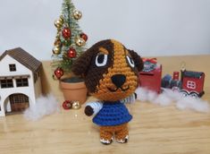 a crocheted dog is standing in front of a christmas tree and toy train