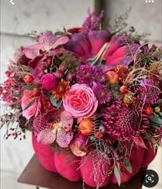 a pink pumpkin filled with lots of flowers