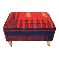 a red and blue foot stool with wheels on the bottom, sitting in front of a white background