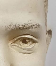 a close up of a white statue with an eye