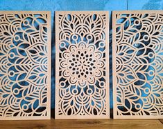 three laser cut panels with intricate designs on them