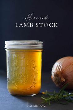 a jar filled with liquid next to garlic and an onion on a counter top,