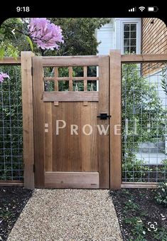 a wooden gate with the word rowe written on it in front of a garden area