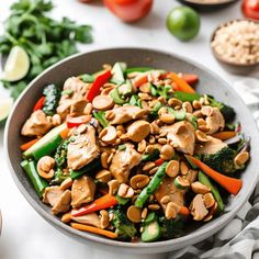 a bowl filled with chicken, broccoli and carrots on top of a table