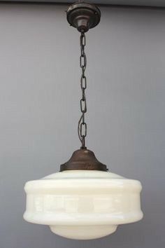 an old fashioned light fixture hanging from the ceiling in a room with gray walls and white trim