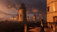 two people are standing on a dock in front of some lighthouses at night time