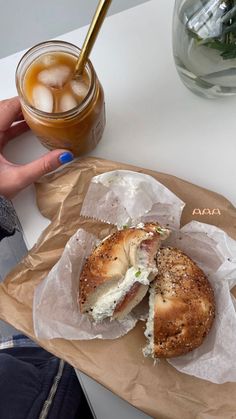 a bagel sandwich and iced tea on a table