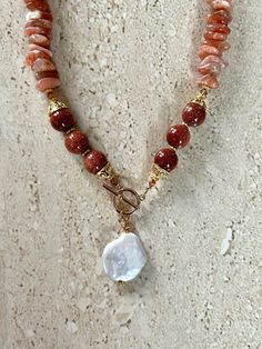 Sunstone Necklace featuring sunstone chips accented with 12MM goldstone beads, gold over copper Bali style bead caps, Swarovski crystals, gold filled toggle clasp and a coin pearl pendant.  Necklace is handmade and measures 18 inches. Sunstone is a sacral chakra stone known for it's leadership, Optimism, and vitality properties. GIFT BOXED Healing Sunstone Gemstone Beads Jewelry, Sacral Chakra Stones, Bali Style, Bali Fashion, Toggle Necklace, Coin Pearls, Classy Jewelry, Handcrafted Artisan Jewelry, Beaded Necklaces