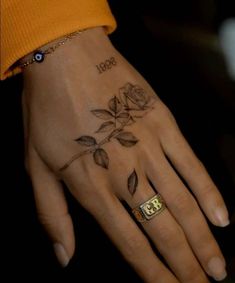 a woman's hand with a rose tattoo on it