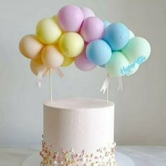 there is a cake with balloons on it