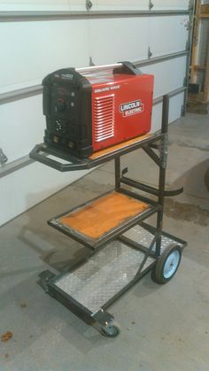 a small portable generator sitting on top of a cart in a garage next to a wall