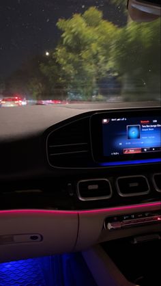 the interior of a car with blue and pink lights on it's dash board