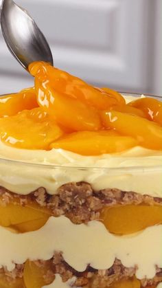 a close up of a cake with fruit on top and a spoon sticking out of it