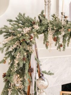 a christmas wreath with pine cones and ornaments hanging from it