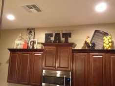 a kitchen with wooden cabinets and an eat sign on the wall above the stove top