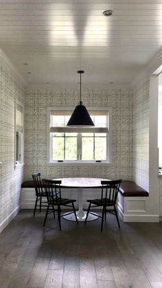 a dining room table with four chairs and a bench in front of the window is shown