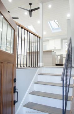 an open door leading to a kitchen and stairs in a home with skylights on the ceiling