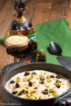 a bowl of oatmeal with raisins in it on a wooden table