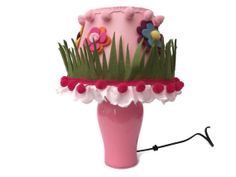 a pink vase with grass and flowers on it