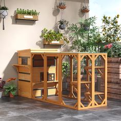 an outdoor area with potted plants on the wall and a wooden structure in the center